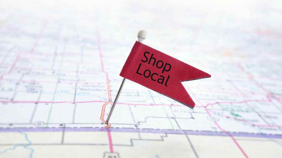 A Flag with a written note "Shop Local" pinned in a map