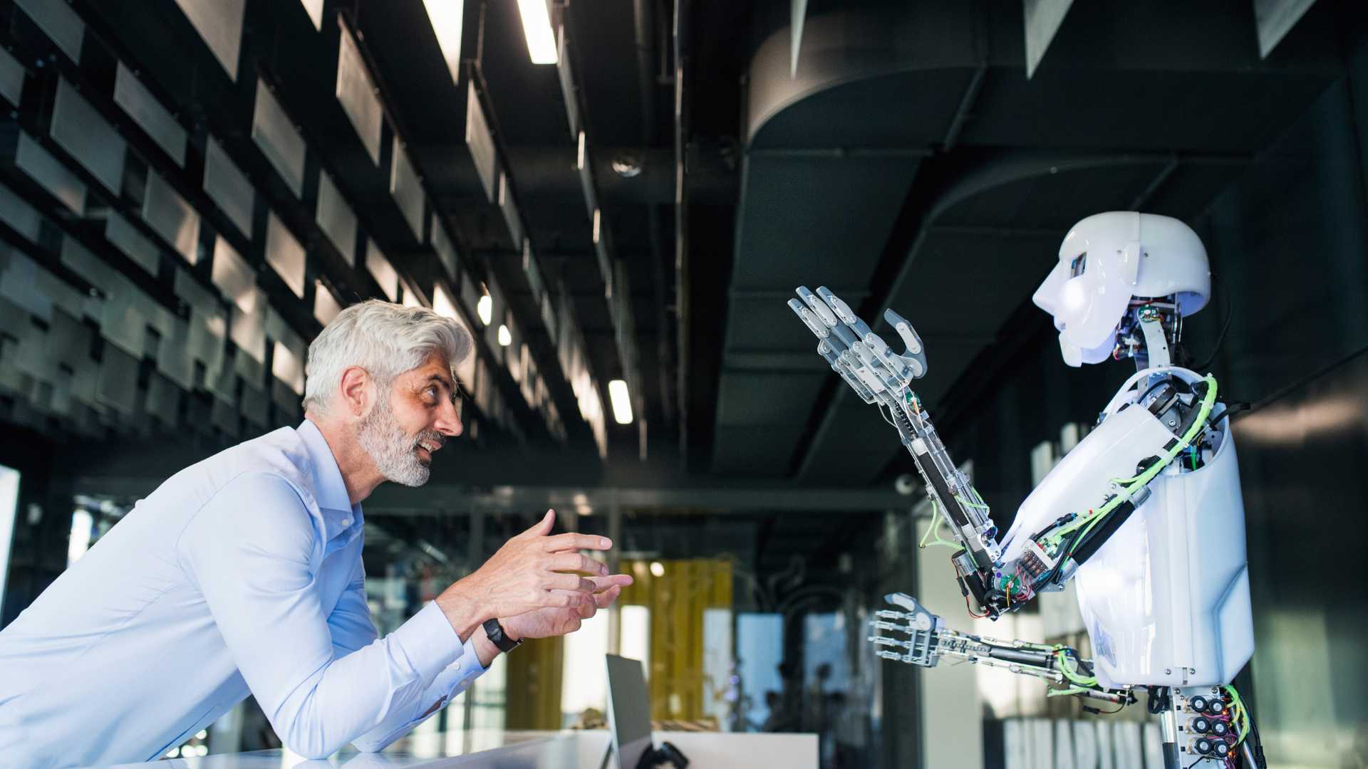 Business man talking to a robot with Artificial Intelligence inside an office